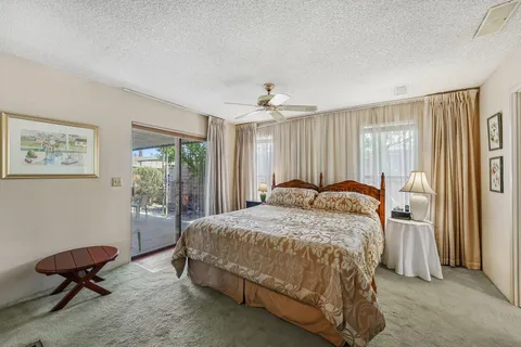 a bed sitting in a spacious bedroom next to a window