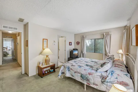 a bedroom with a bed and large windows