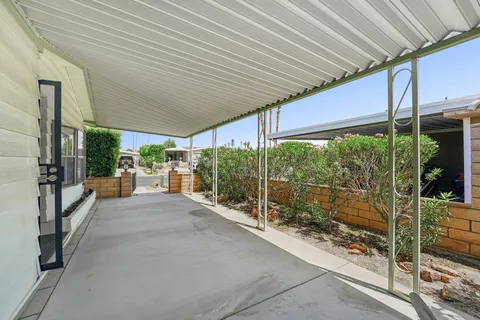 a patio with glass top table and chairs