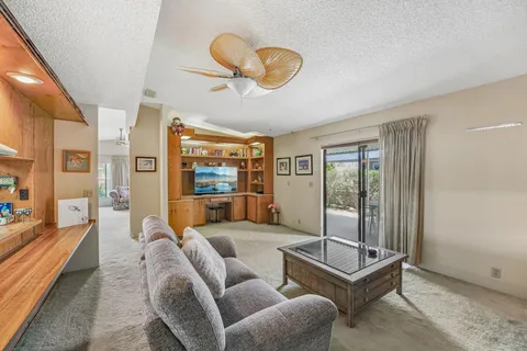 a living room with furniture a flat screen tv and a large window