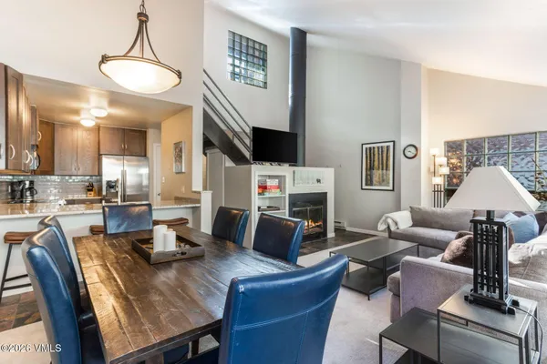 a kitchen with stainless steel appliances granite countertop a chairs a sink and a refrigerator