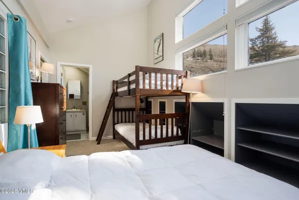 a bedroom with a bed and a flat tv screen on dresser