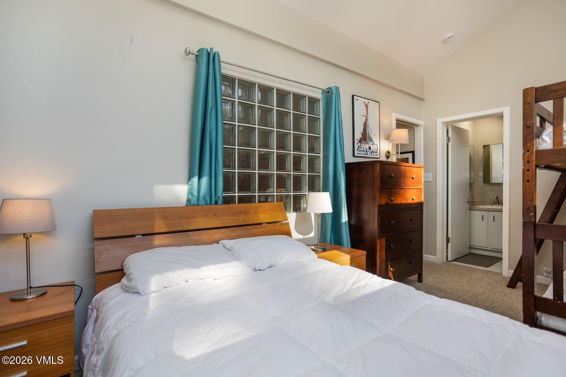 3911 Big Horn Road, Unit 1D Vail, CO 81657 - Photo 24 of 31 a bedroom with a bed and a flat tv screen on dresser