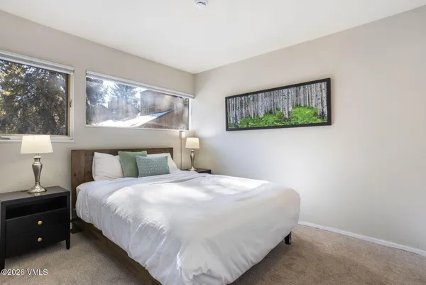 a bedroom with a bed and painting on the wall