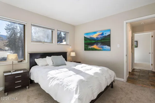 a large bed sitting in a bedroom next to a window
