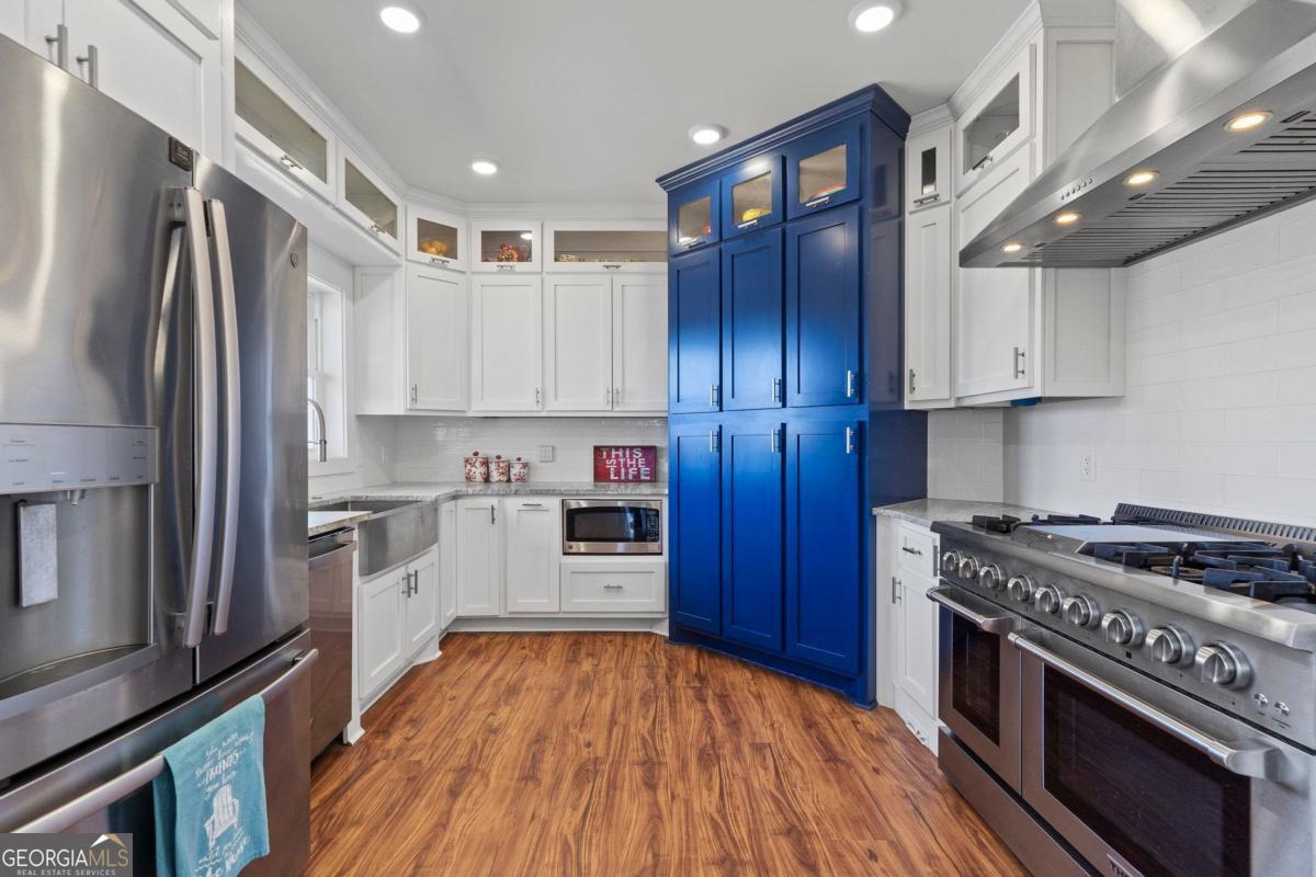 392 Big Oconee River Road Sparta, GA 31087 - Photo 15 of 69 a kitchen with stainless steel appliances granite countertop a stove top oven a refrigerator and cabinets with wooden floors
