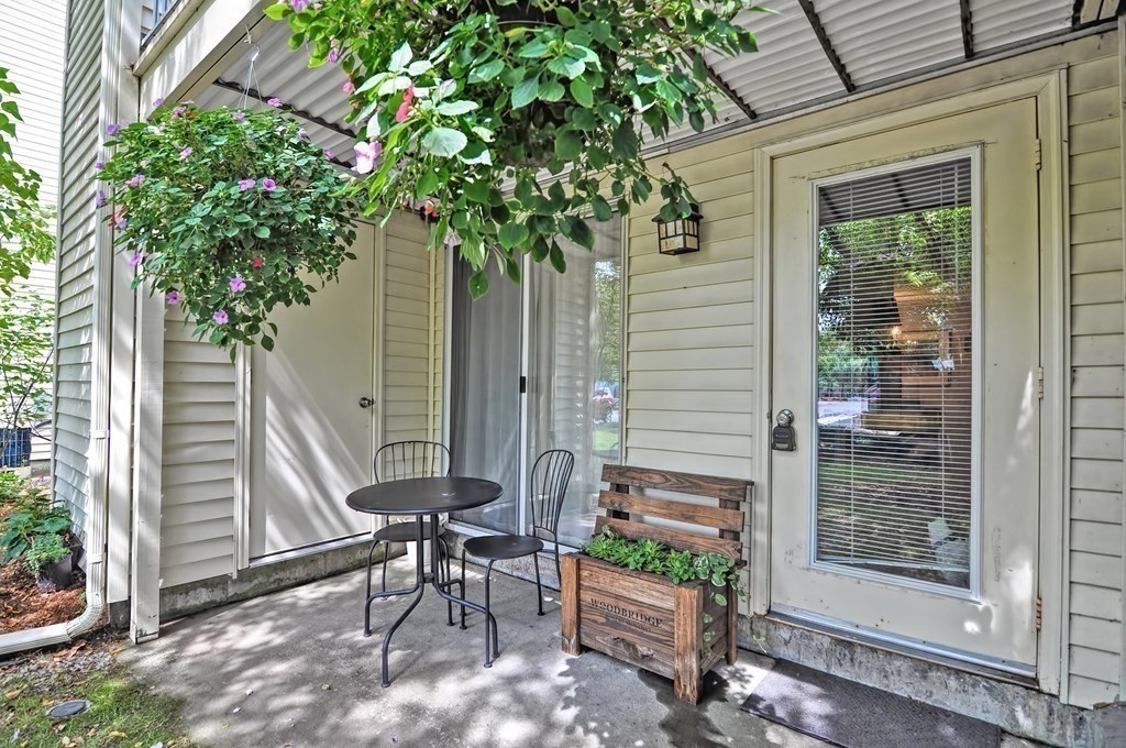 8 Walden Drive, Unit 13 Natick, MA 01760 - Photo 4 of 38 a view of a porch with a table and chairs and potted plants