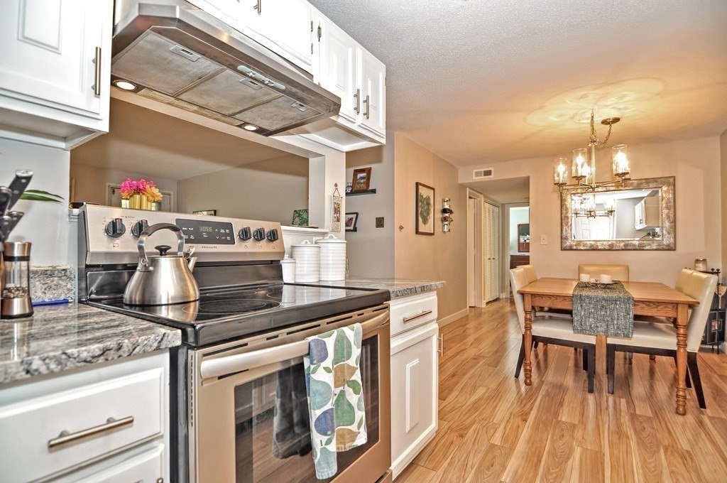 8 Walden Drive, Unit 13 Natick, MA 01760 - Photo 8 of 38 a kitchen with stainless steel appliances granite countertop a stove and a wooden floors