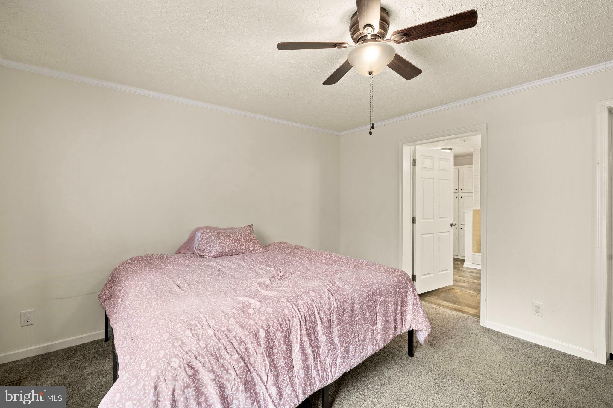 13115 Arcadia Road Woodford, VA 22580 - Photo 21 of 44 a bedroom with a bed and a chandelier