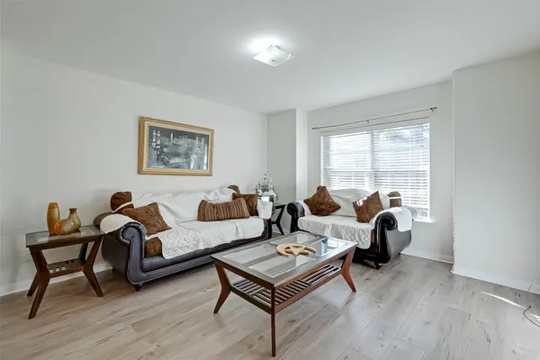 a living room with furniture a rug a lamp and a window