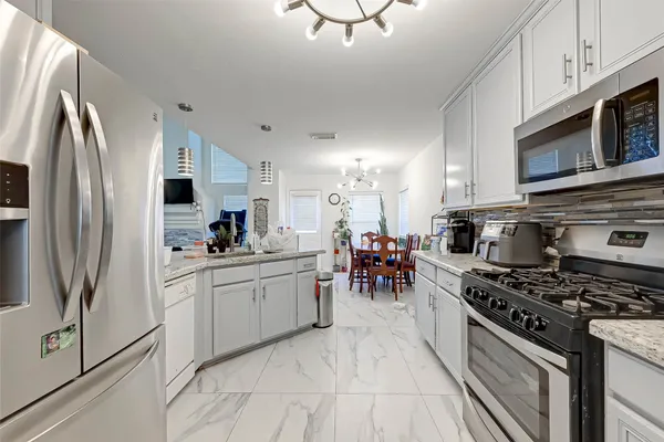 a kitchen with stainless steel appliances a stove a sink and a refrigerator