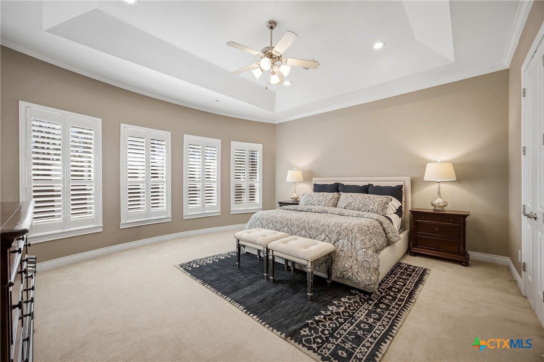 2427 Anderson Point Lane Spring, TX 77388 - Photo 23 of 47 a spacious bedroom with a large bed a chandelier and windows