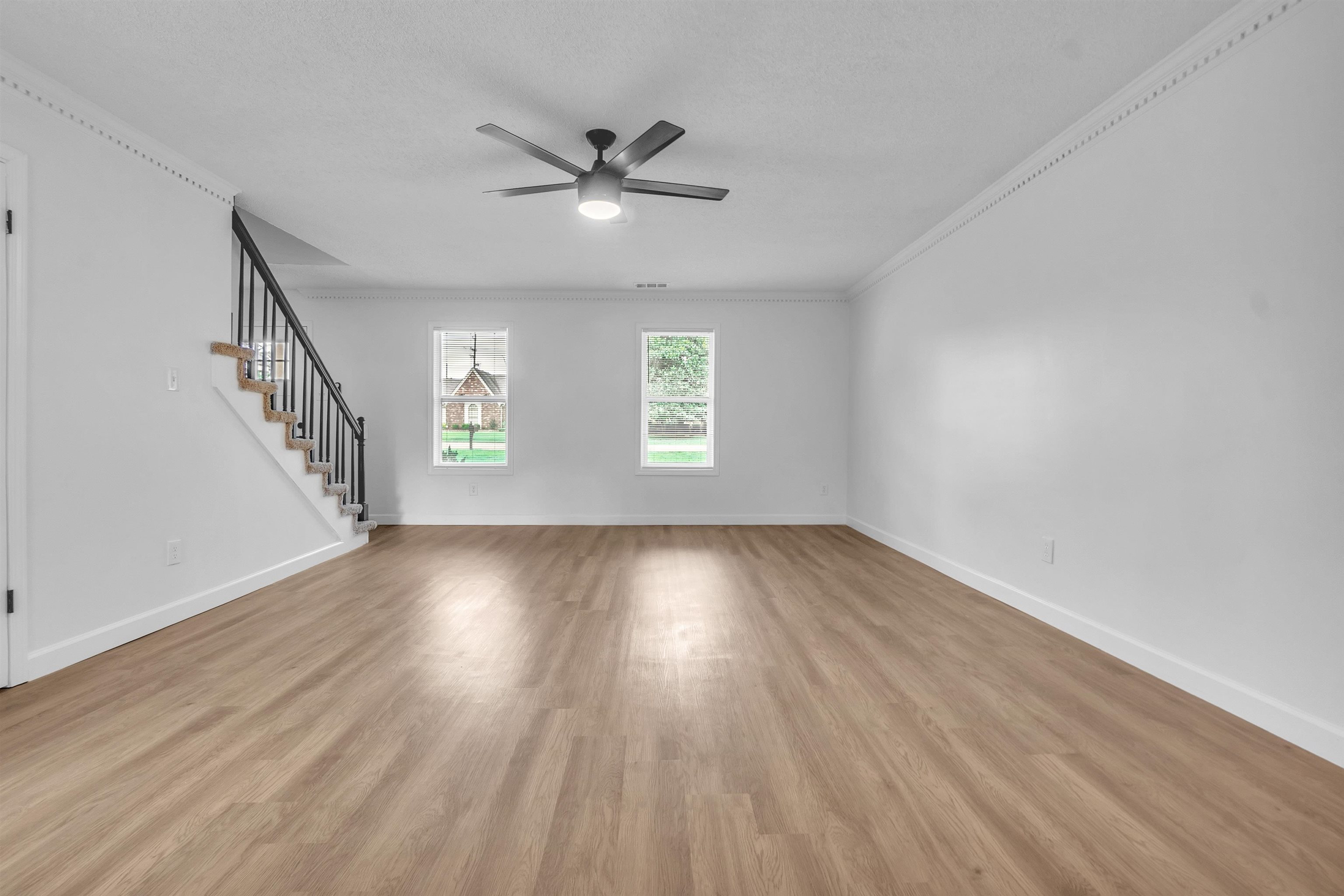 488 West Regis Place Memphis, TN 38018 - Photo 4 of 17 Unfurnished living room with light wood-style flooring, a ceiling fan, and ornamental molding