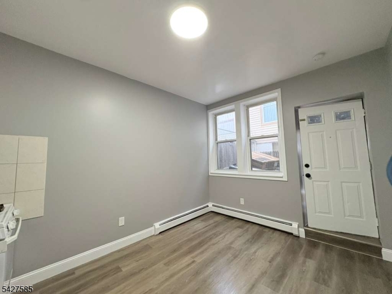 70 Main Street Garfield, NJ 07026 - Photo 8 of 9 an empty room with wooden floor and windows