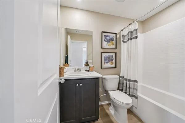 a bathroom with a toilet sink vanity tub and mirror