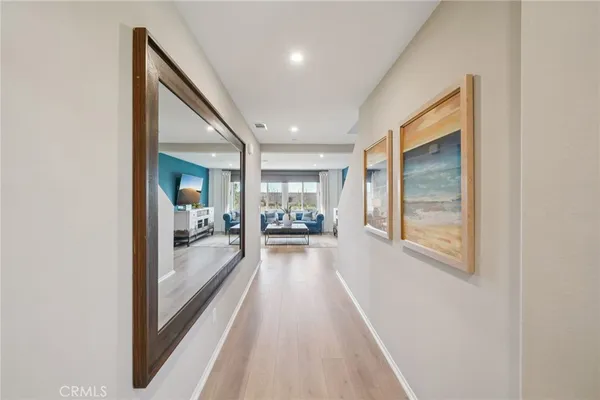 a view of a hallway with wooden floor and a living room