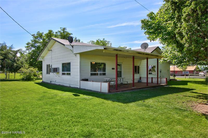 200 East Evans Road Wapato, WA 98951 - Photo 2 of 19 a front view of a house with a garden and porch