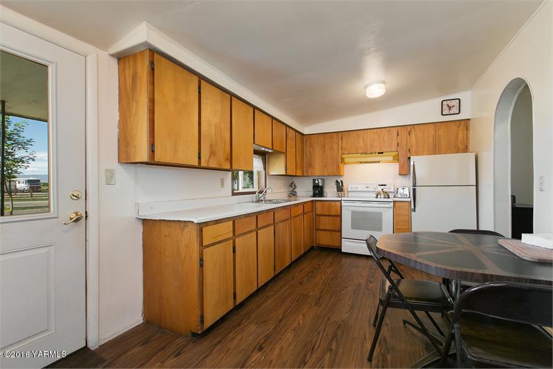 200 East Evans Road Wapato, WA 98951 - Photo 12 of 19 a kitchen with a table chairs refrigerator and cabinets