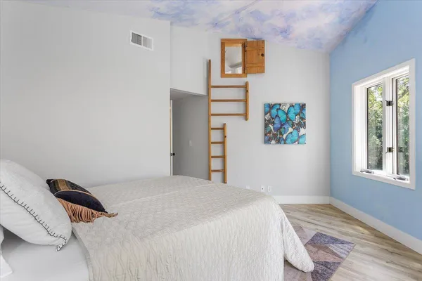a bedroom with a bed and a painting on the wall