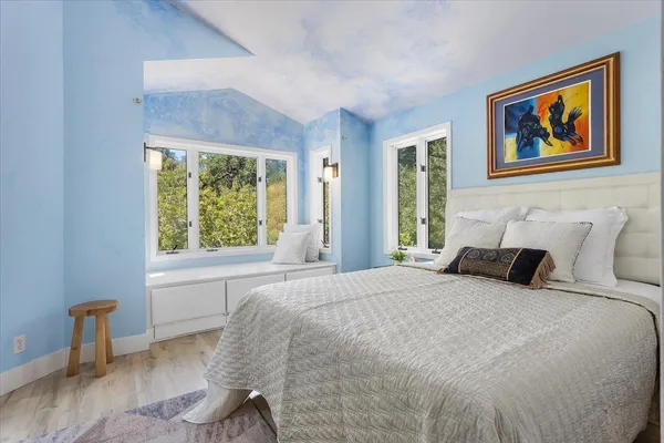 a bedroom with a bed and a large window