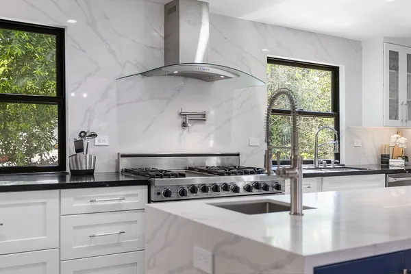 a kitchen with a stove a window and cabinets