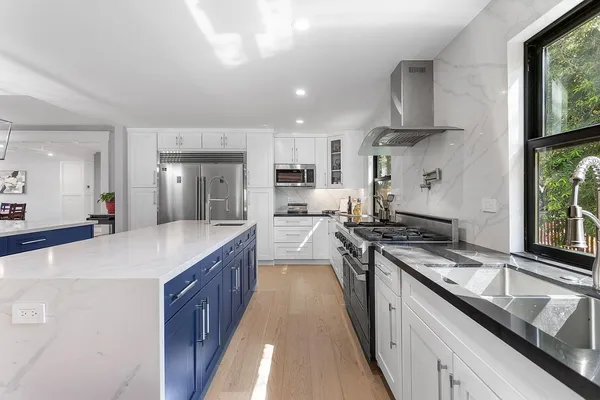 a kitchen with stainless steel appliances granite countertop a sink stove and refrigerator