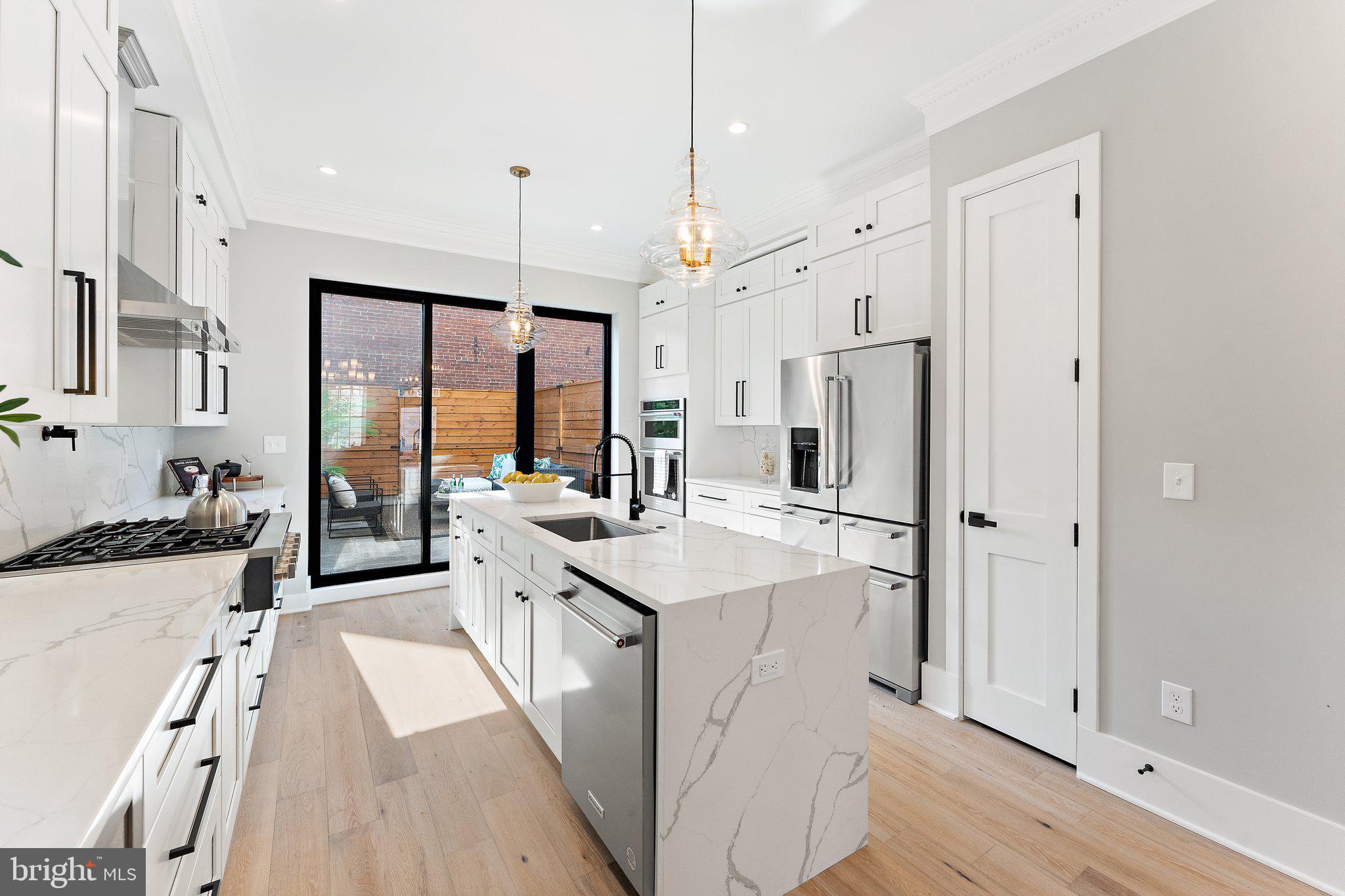 900 8th Street Northeast Washington, DC 20002 - Photo 12 of 50 a kitchen with stainless steel appliances granite countertop a refrigerator a sink dishwasher a stove and white countertops with wooden floor