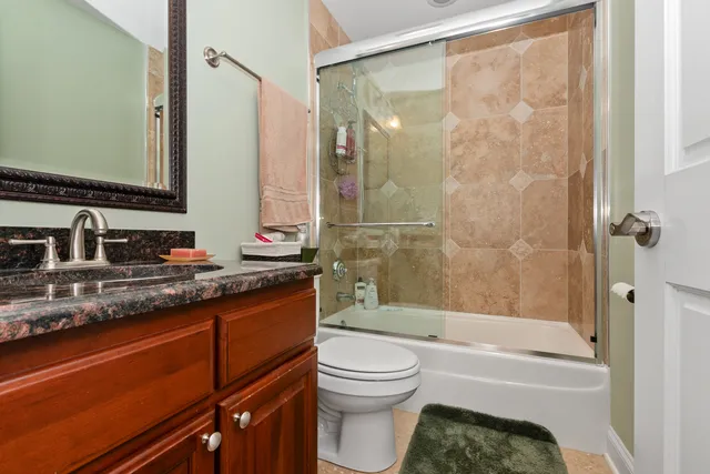 a bathroom with a granite countertop sink toilet and shower