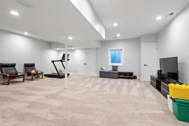 a view of a room with gym equipment and a flat screen tv