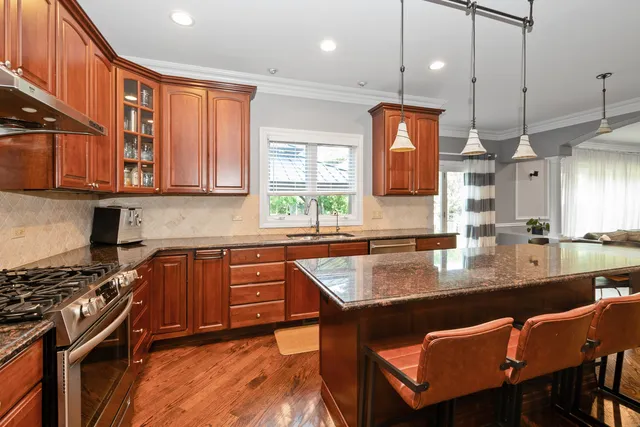 a kitchen with stainless steel appliances granite countertop a stove a sink and a refrigerator