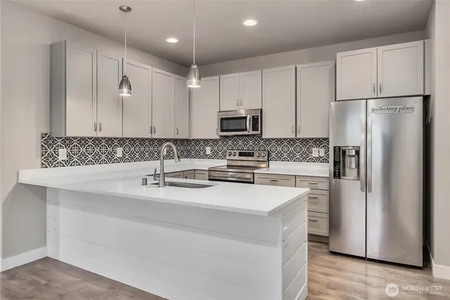 a kitchen with stainless steel appliances a refrigerator sink and microwave