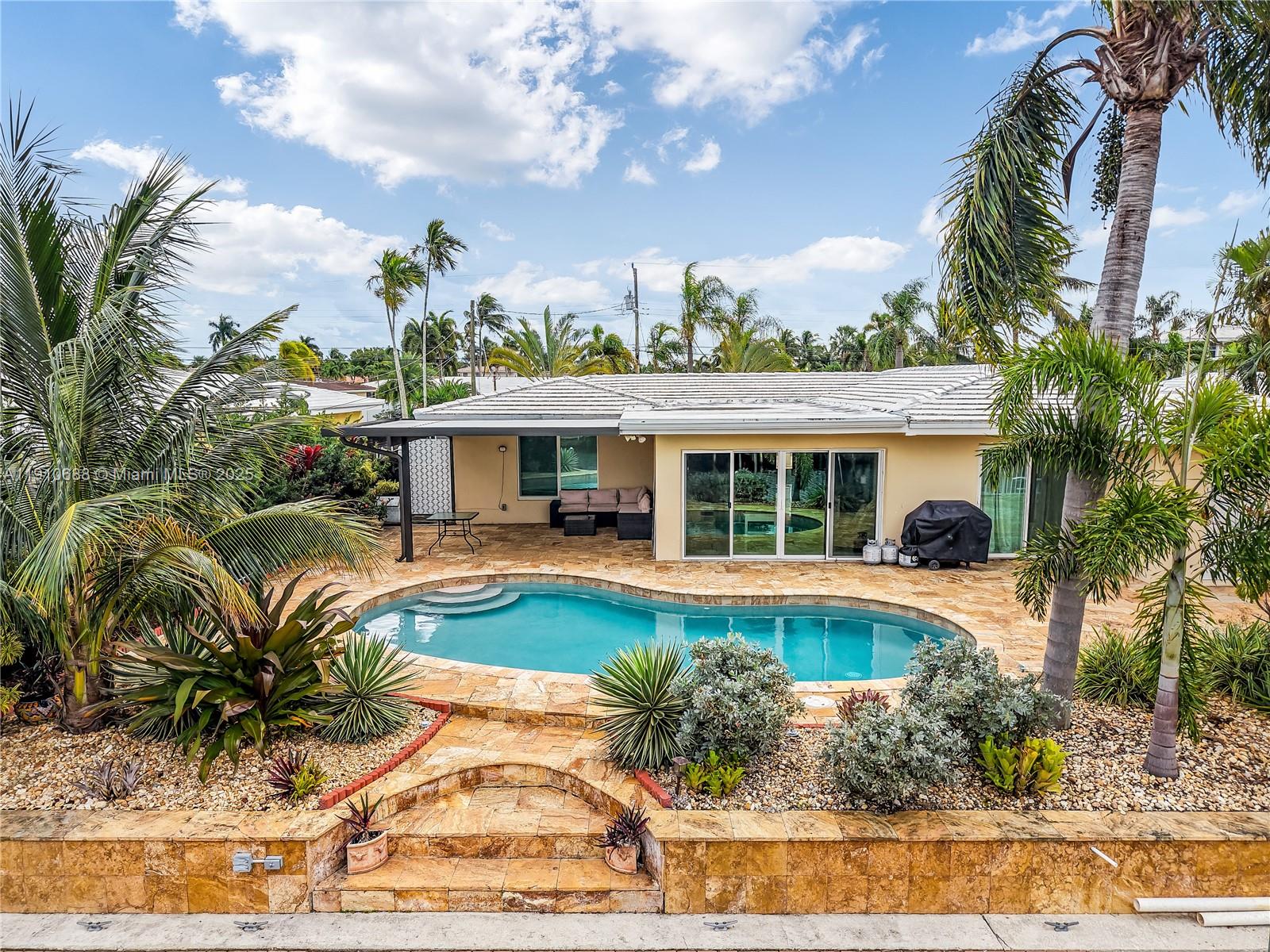 281 Southeast 3rd Court Pompano Beach, FL 33060 - Photo 3 of 39 a front view of a house with swimming pool having outdoor seating