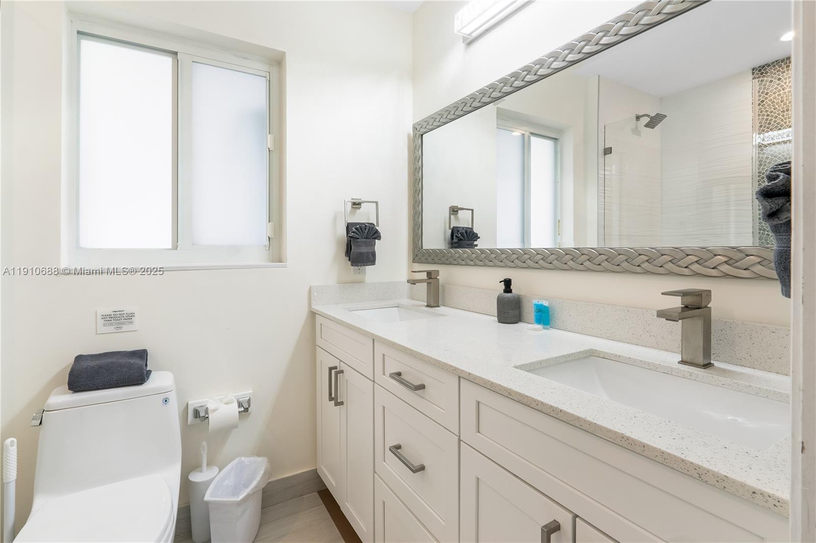 281 Southeast 3rd Court Pompano Beach, FL 33060 - Photo 37 of 39 a bathroom with a sink a toilet and a mirror
