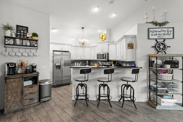 a view of a kitchen with dining area a sink and wooden floor