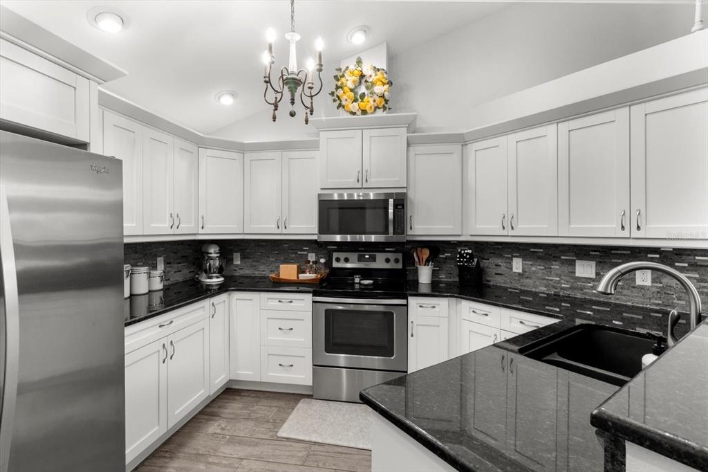 5317 West Tortuga Loop Lecanto, FL 34461 - Photo 13 of 37 a kitchen with granite countertop a sink stainless steel appliances and white cabinets