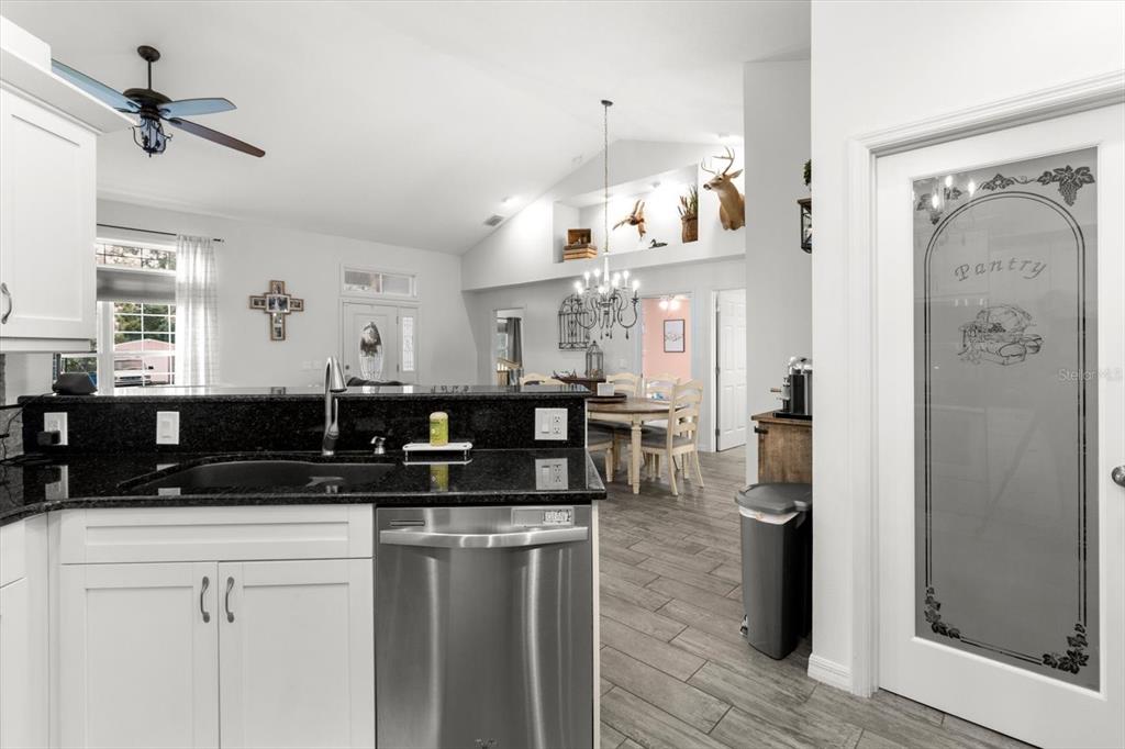 5317 West Tortuga Loop Lecanto, FL 34461 - Photo 14 of 37 a kitchen with stainless steel appliances granite countertop a sink dishwasher a refrigerator and white cabinets with wooden floor