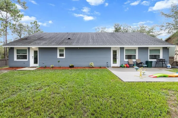 a view of a house with backyard and porch