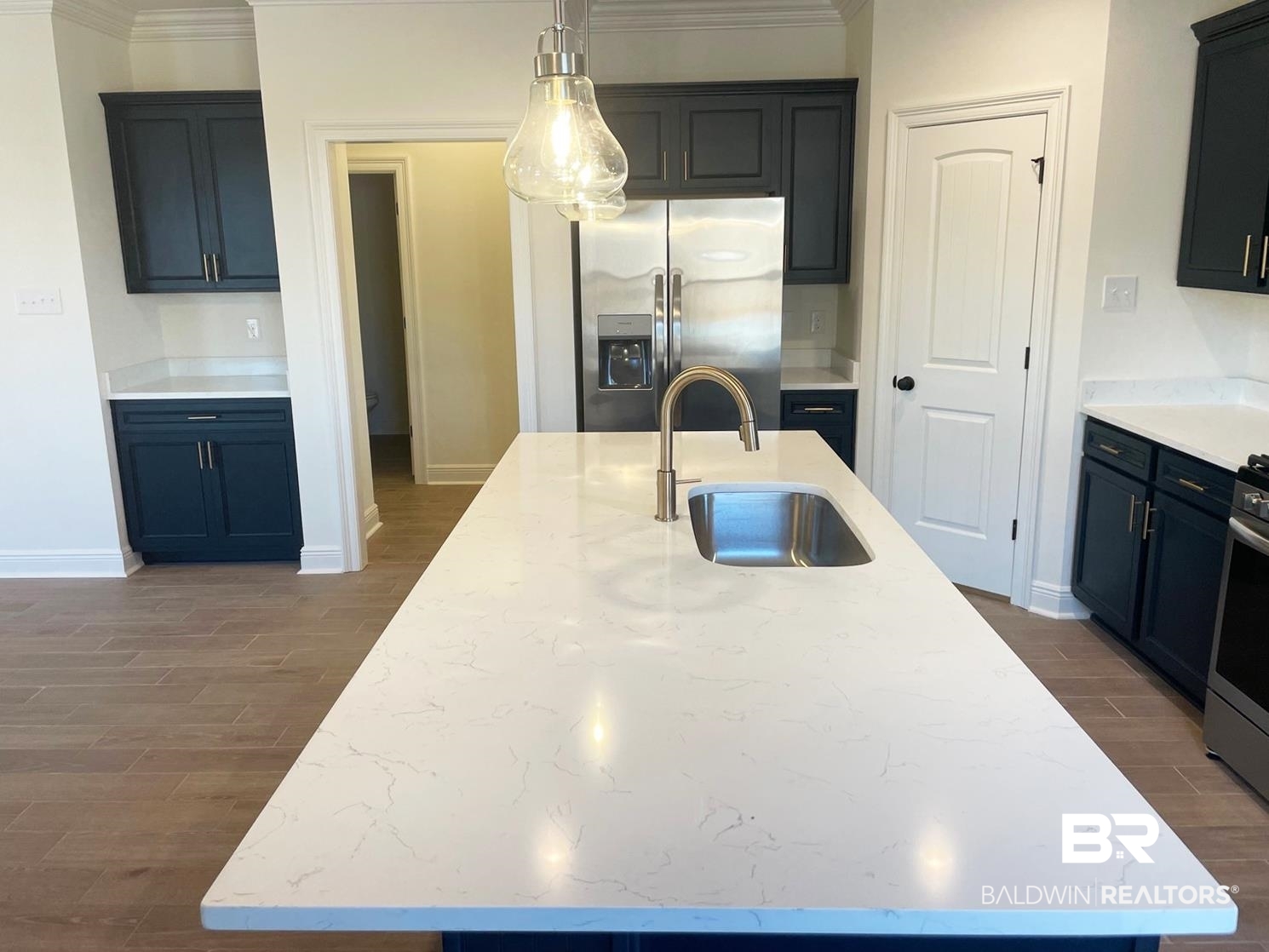1363 Fenton Circle Foley, AL 36535 - Photo 3 of 20 Kitchen featuring dark wood-type flooring, sink, stainless steel refrigerator with ice dispenser, light stone countertops, and an island with sink