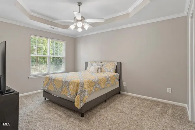 a spacious bedroom with a bed and a flat screen tv