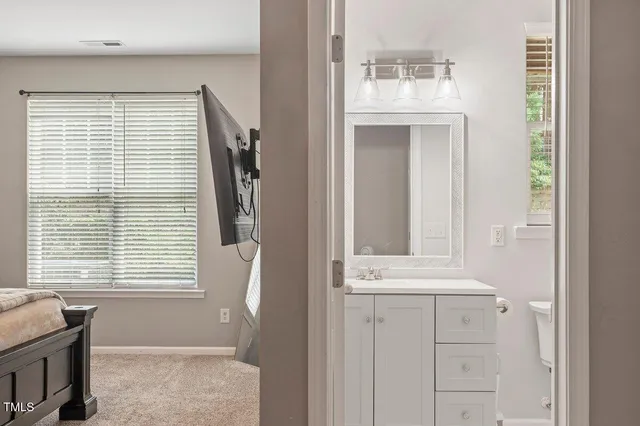 a bathroom with a sink a mirror and next to a window