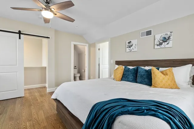 a bedroom with a large bed and a chandelier