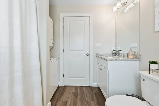 a bathroom with a sink a toilet a mirror and shower