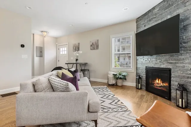 a living room with furniture a flat screen tv and a fireplace
