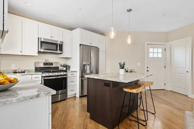 a kitchen with stainless steel appliances a stove a sink a microwave a refrigerator and cabinets