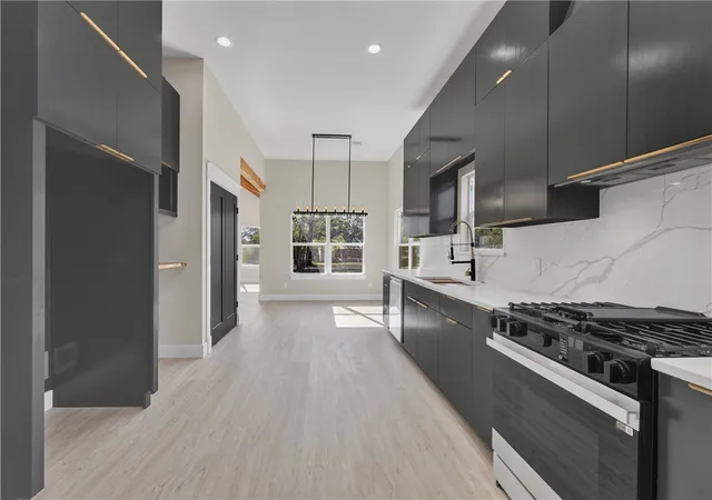 a kitchen with stainless steel appliances granite countertop a stove and a refrigerator