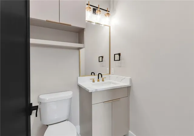 a bathroom with a toilet sink and mirror