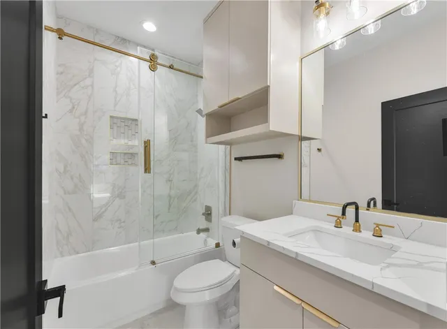 a bathroom with a granite countertop sink toilet and shower