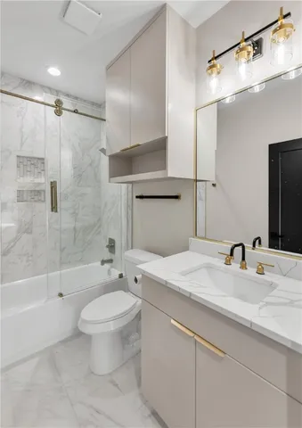 a bathroom with a granite countertop sink toilet and shower