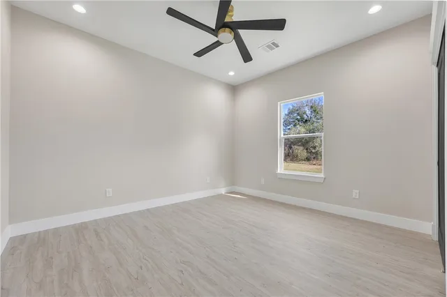 an empty room with a window and a ceiling fan