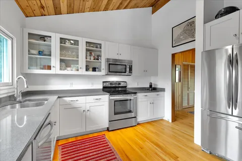 a kitchen with stainless steel appliances granite countertop a refrigerator sink and stove